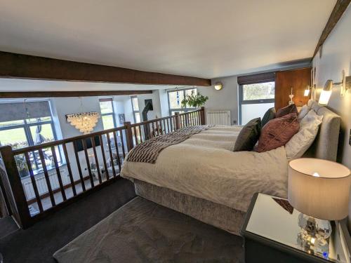 a bedroom with a large bed on a balcony at The Dairy at Brackenthwaite Farm in Carnforth