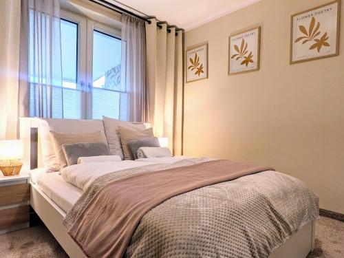 a bedroom with a large bed with a window at SB Apartment with Sauna in Kołobrzeg