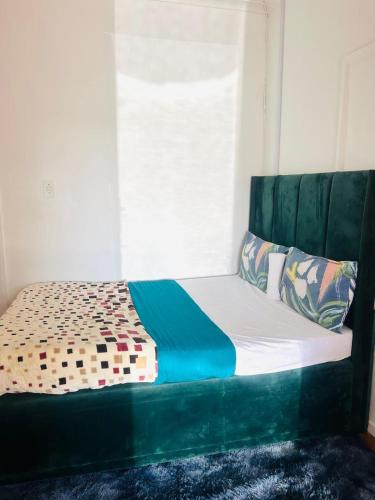 a bed with a green headboard in a room at Executive Accommodation Bellville 2 in Cape Town