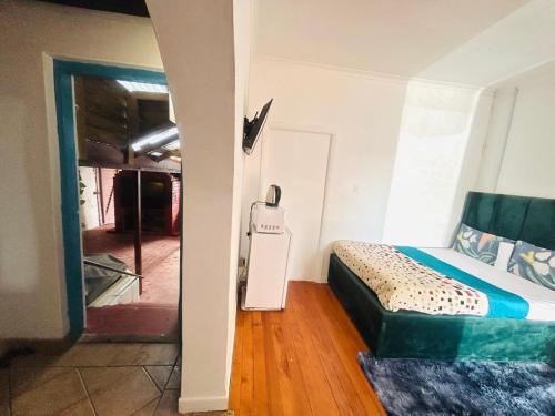 a room with a bed and a refrigerator in it at Executive Accommodation Bellville 2 in Cape Town