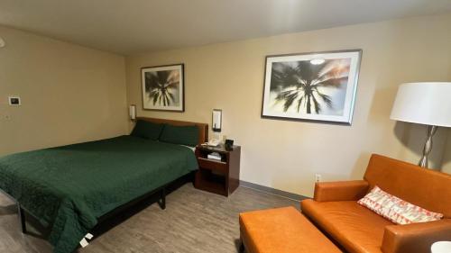 a hotel room with a bed and a couch at Chesaning INN & Suites in Chesaning