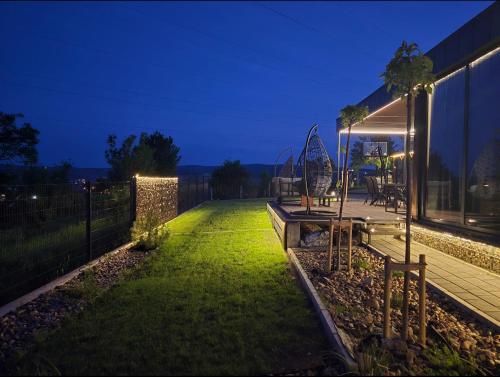 a backyard at night with a fence and a lawn at Balans house in Petrovaradin
