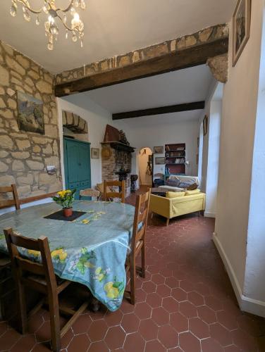 une cuisine et un salon avec une table et des chaises dans l'établissement Maison de famille entre mer & collines - Charme, citronniers et tranquillité - accès marche et sentier 3 min, à Menton