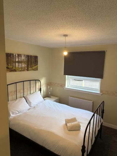 a bedroom with a large white bed with a window at 2-Bed City Apartment by Glasgow Green in Glasgow