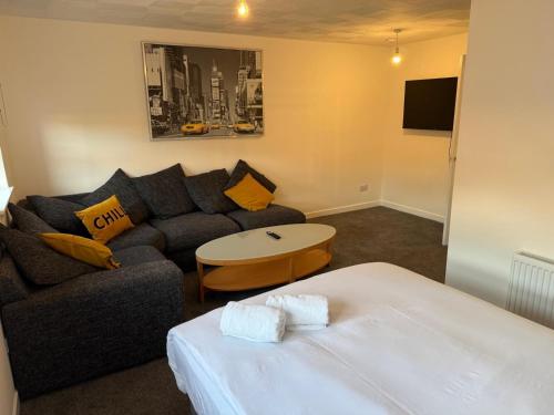 a living room with a couch and a table at 2-Bed City Apartment by Glasgow Green in Glasgow