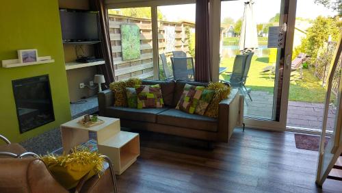 a living room with a couch and a fireplace at Vakantiehuis Jade in Bruinisse