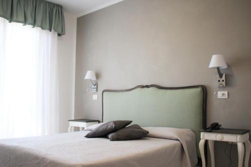 a bedroom with a bed with two pillows on it at Hotel Piccolo Mondo in Lido di Camaiore