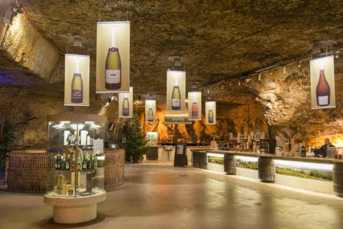 Cette chambre comprend un bar avec des bouteilles sur le mur. dans l'établissement Le Chaleureux à Auxerre, à Auxerre