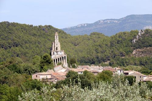 a building with a tower on top of a village at Terrasses De Saint Martin - Très Calme et Agréable avec Grande Terrasse Ombragée - Résidence Privée - Idéalement située - Parking privatif possible in Montélimar