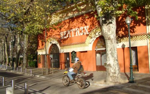 a person riding a bike in front of a building at Maison Super Calme et Confortable - Idéalement Située - Clim - Vue Montagnes - Piscine Partagée - Parking Gratuit - Lou Tranquillou in Sauzet