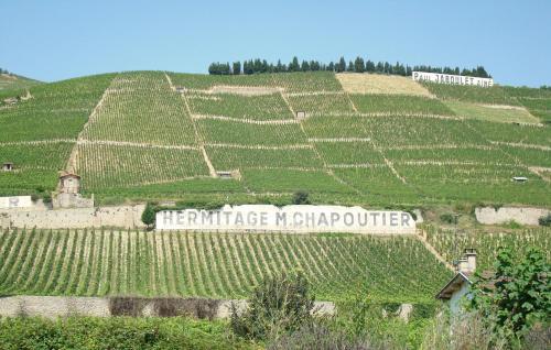 a vineyard with a sign that reads heritage modifier on a hill at Maison Super Calme et Confortable - Idéalement Située - Clim - Vue Montagnes - Piscine Partagée - Parking Gratuit - Lou Tranquillou in Sauzet