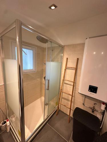 une douche avec une porte vitrée dans une salle de bain dans l'établissement Maison provençale, à Ceyreste