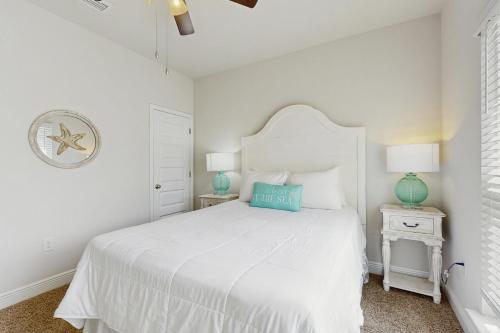 a white bedroom with a white bed and two night stands at WindMark - Sea Forever in Highland View