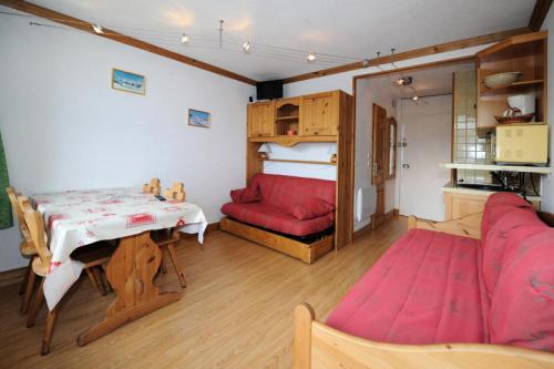 un salon avec une table et un canapé rouge dans l'établissement Résidence Chaviere - Studio agréable · Au pied des pistes · Balcon MAE-2754, aux Menuires
