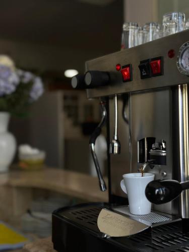a coffee maker with a cup on a counter at Hotel Il Giardino degli Aranci in Nola