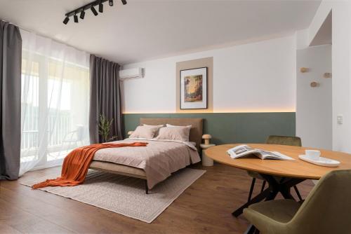 a bedroom with a bed and a wooden table at Hubix Suites - City of Mara in Timişoara