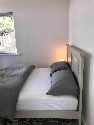 a bed with two pillows and a window in a room at PERIWINKLE COTTAGE, with the most amazing sea view in Youghal