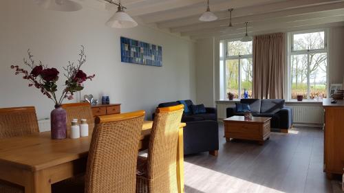 een eetkamer en een woonkamer met een tafel en stoelen bij Boerderij de Borgh in Westerbork