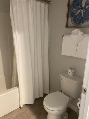 a white bathroom with a toilet and a shower at Ocean Shores Resort in Ocean Shores