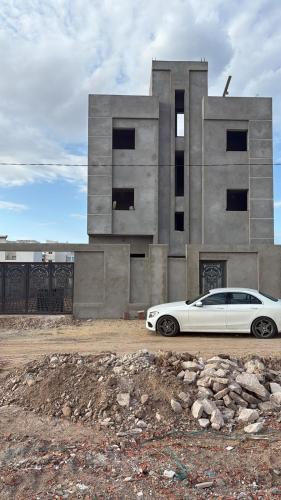 a white car parked in front of a building at Résidence El selem in Salakta