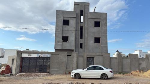 a white car parked in front of a building at Résidence El selem in Salakta