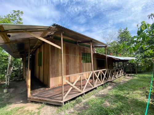 a wooden house with a roof on the grass at YAKU albergue y camping in Padre Cocha