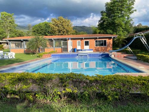 a swimming pool in front of a house at finca el eden ginebra valle in Ginebra