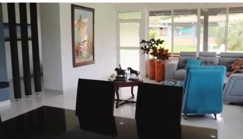 a living room with a table and blue chairs at finca el eden ginebra valle in Ginebra