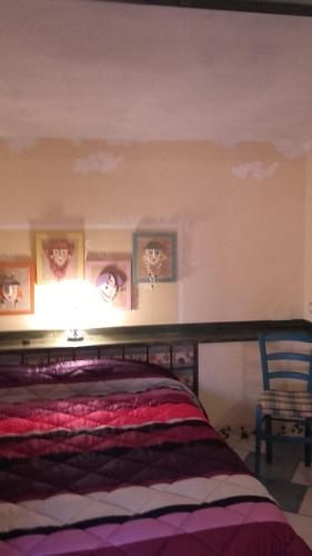a bedroom with a bed and a wall with pictures at L'Antica Cantina in Usini