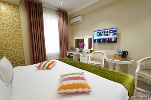 a hotel room with a bed and a tv at HOTEL SILK ROAD EMPIRE SAMARKAND in Samarkand