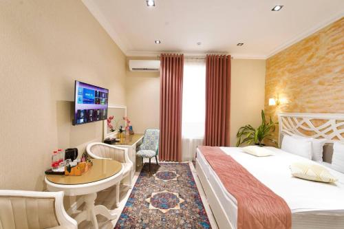 a hotel room with a bed and a desk at HOTEL SILK ROAD EMPIRE SAMARKAND in Samarkand