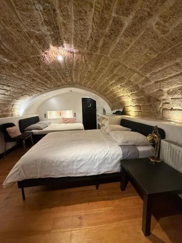 - une chambre avec deux lits et un plafond en pierre dans l'établissement Appartement atypique 6 pers centre ville de Montpellier, à Montpellier