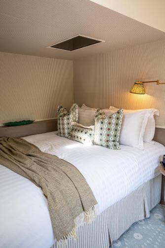 a bedroom with a large white bed with pillows at Fairyhill in Reynoldston