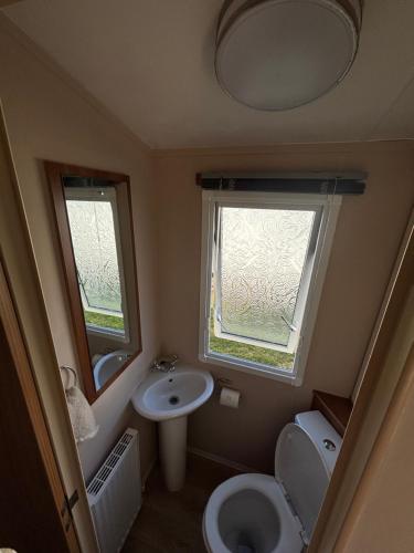 a small bathroom with a toilet and a sink at New beach Holidays in Dymchurch