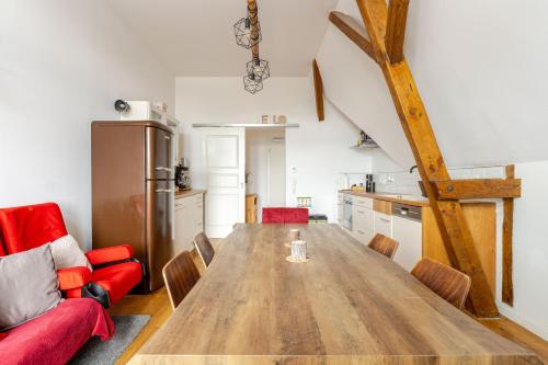a kitchen with a wooden table and red chairs at Wohnen wie im Schloss - Alter Bahnhof von Kruft in Kruft