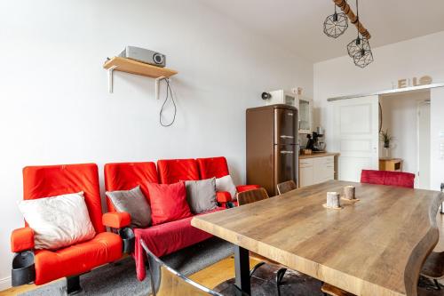 a living room with a red couch and a wooden table at Wohnen wie im Schloss - Alter Bahnhof von Kruft in Kruft