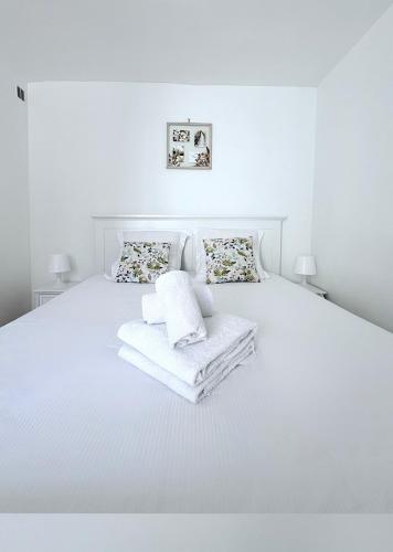 - une chambre blanche avec un lit blanc et des serviettes dans l'établissement Le Roy Soleil Classé 3 étoiles Cosy & Cœur du quartier Saint-Louis, à Versailles