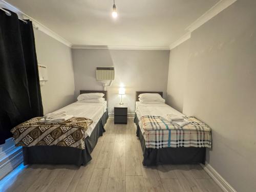 a room with two beds and a lamp in it at Queensborough Apartment, Central London in London
