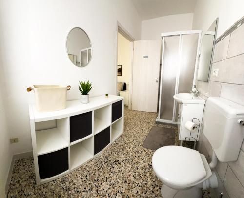 a bathroom with a toilet and a sink and a mirror at Malpensa Rooms in Case Nuove