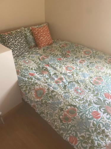 a bed with a flowered comforter in a room at Rooms only Galway city in Galway