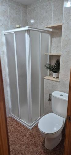 e bagno con servizi igienici bianchi e doccia. di A fantastic apartment on the beach a Canet de Berenguer