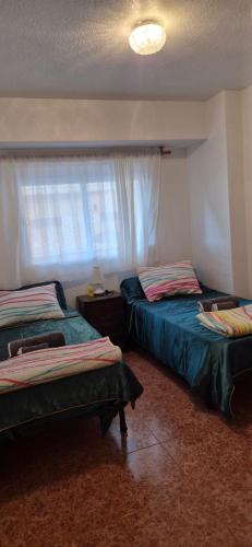 una camera da letto con due letti e una finestra di A fantastic apartment on the beach a Canet de Berenguer