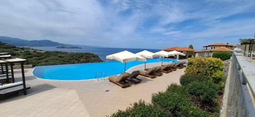 a swimming pool with chairs and umbrellas on a building at Villa Molivos Castle in Mithymna
