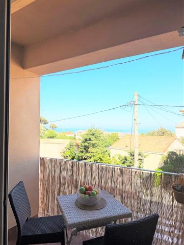 une table avec un bol de fruits sur un balcon dans l'établissement Appartement à Erbalunga face à la mer, à Brando