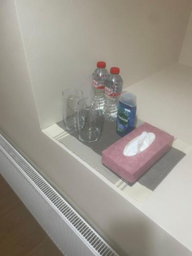 a shelf with glasses and bottles of water on it at Rooms only Galway city in Galway