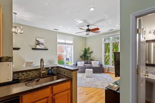 a kitchen and living room with a ceiling fan at Warehouse District Modern Condo with Private Garage in Raleigh