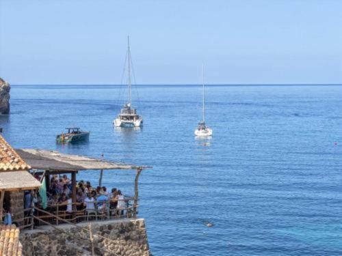 a group of people sitting on a pier with boats in the water at Elegant Villa with Private Pool in Porto Cristo