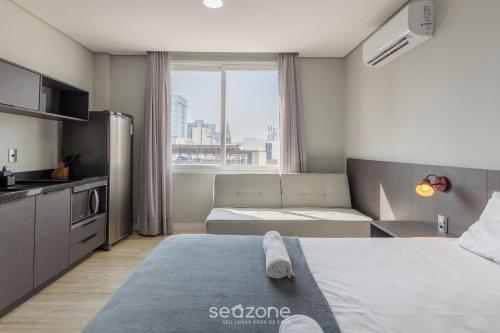 a hotel room with two beds and a kitchen at TCO - Apartamentos no Centro Histórico Porto Alegre/RS in Porto Alegre