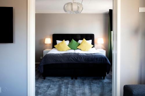a bedroom with a bed with yellow and green pillows at Welcome Hotel Barkarby in Järfälla