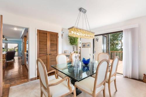 a dining room with a glass table and chairs at Heavenly Carmel - Stay for 10 in Carmel